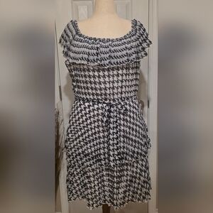 Cato off-shoulder pleated dress in black and white houndstooth print with a tie